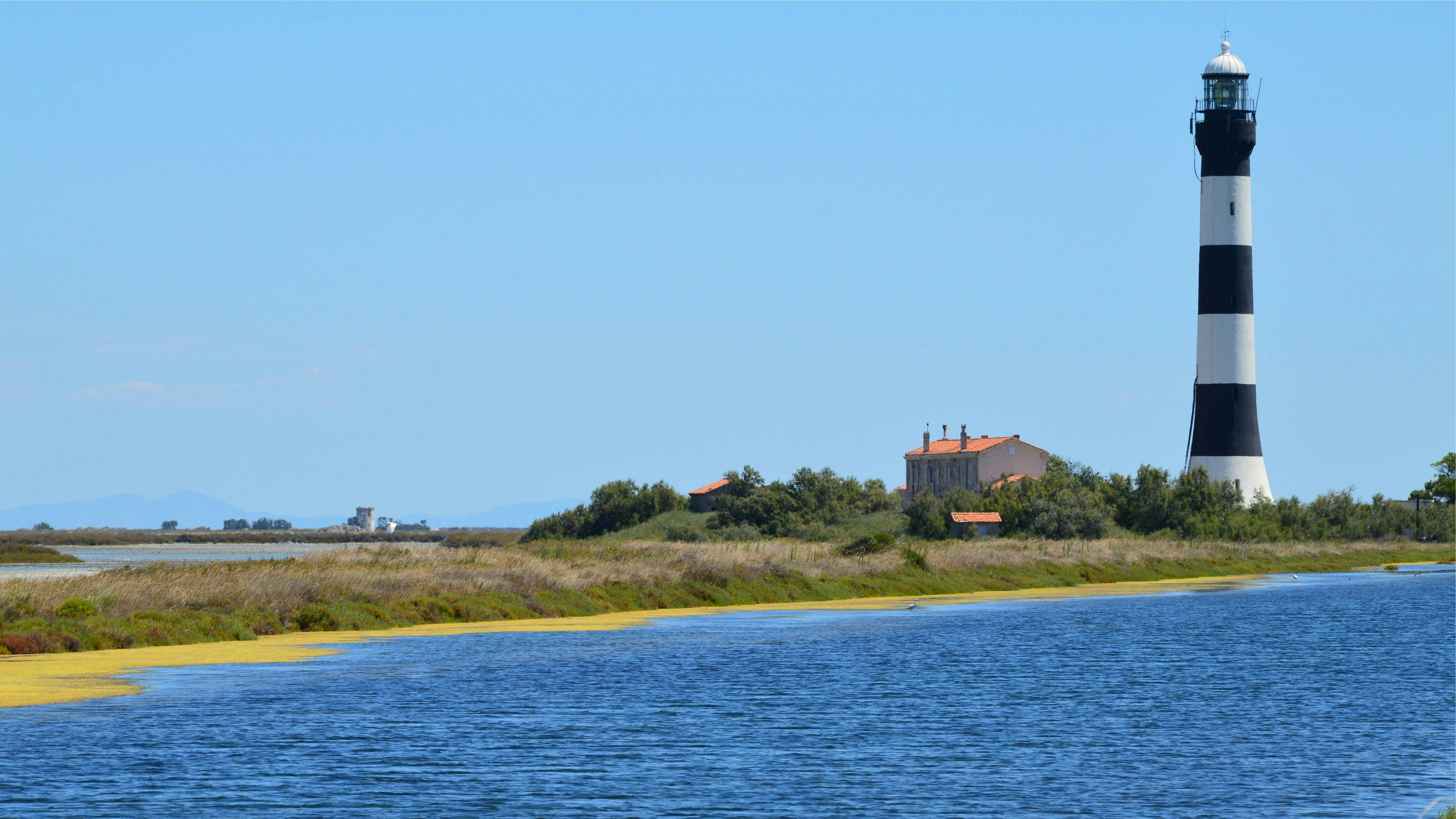 a black and white lighthouse near a body of water