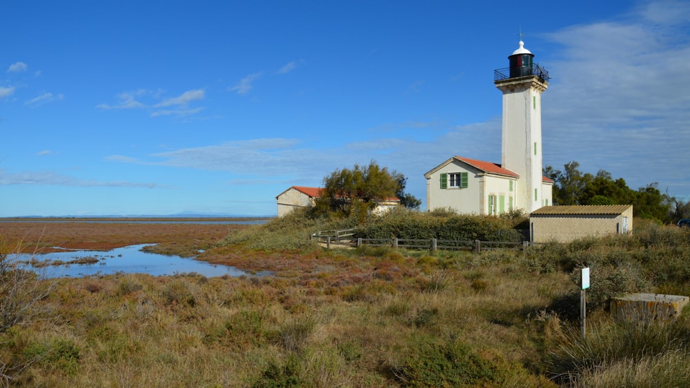 a lighthouse on a small island in the middle of a marsh
