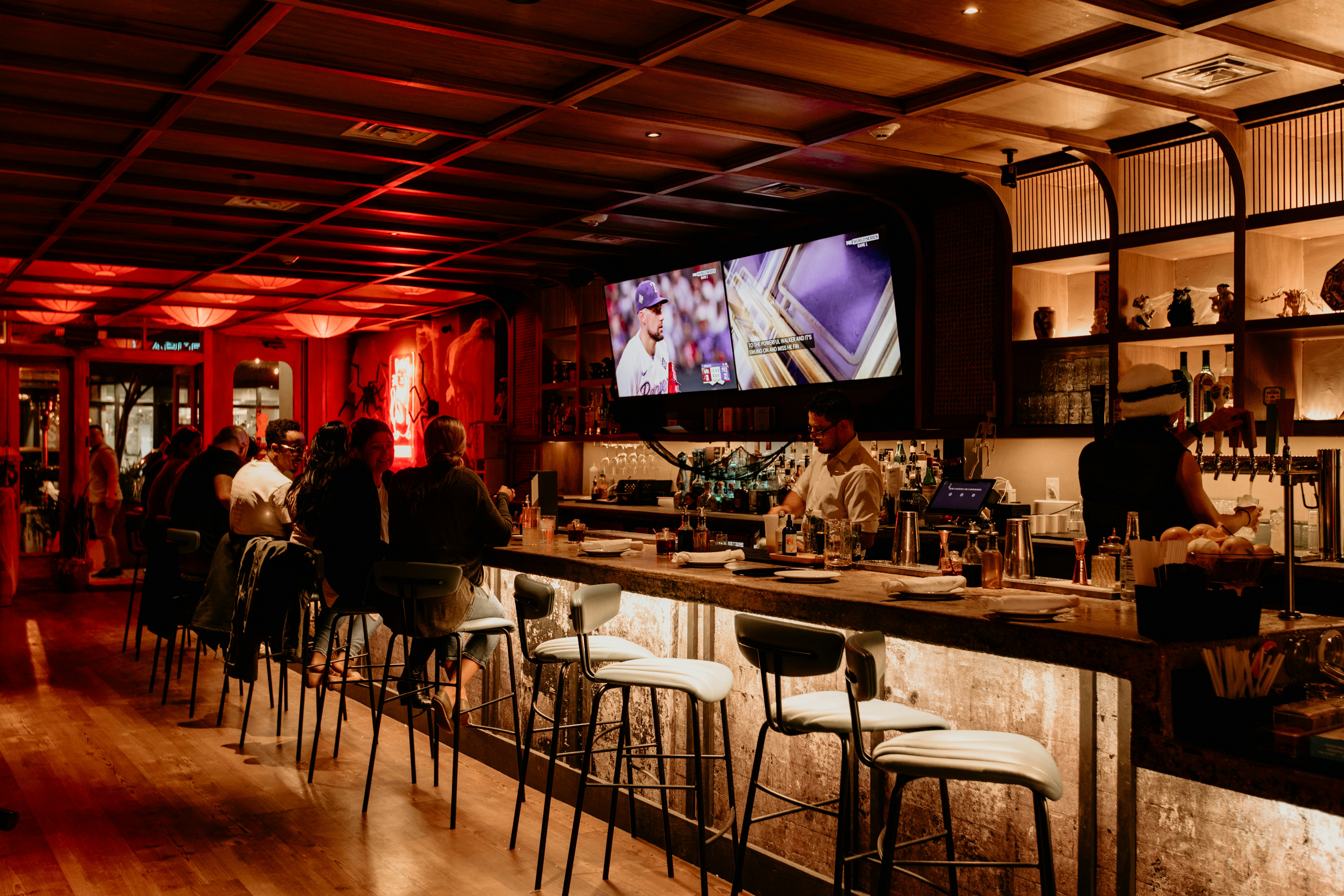 바에 앉아 TV를 보고 있는 한 무리의 사람들