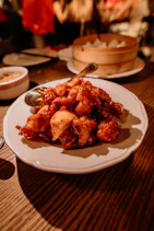 a white plate topped with fried food on top of a wooden table