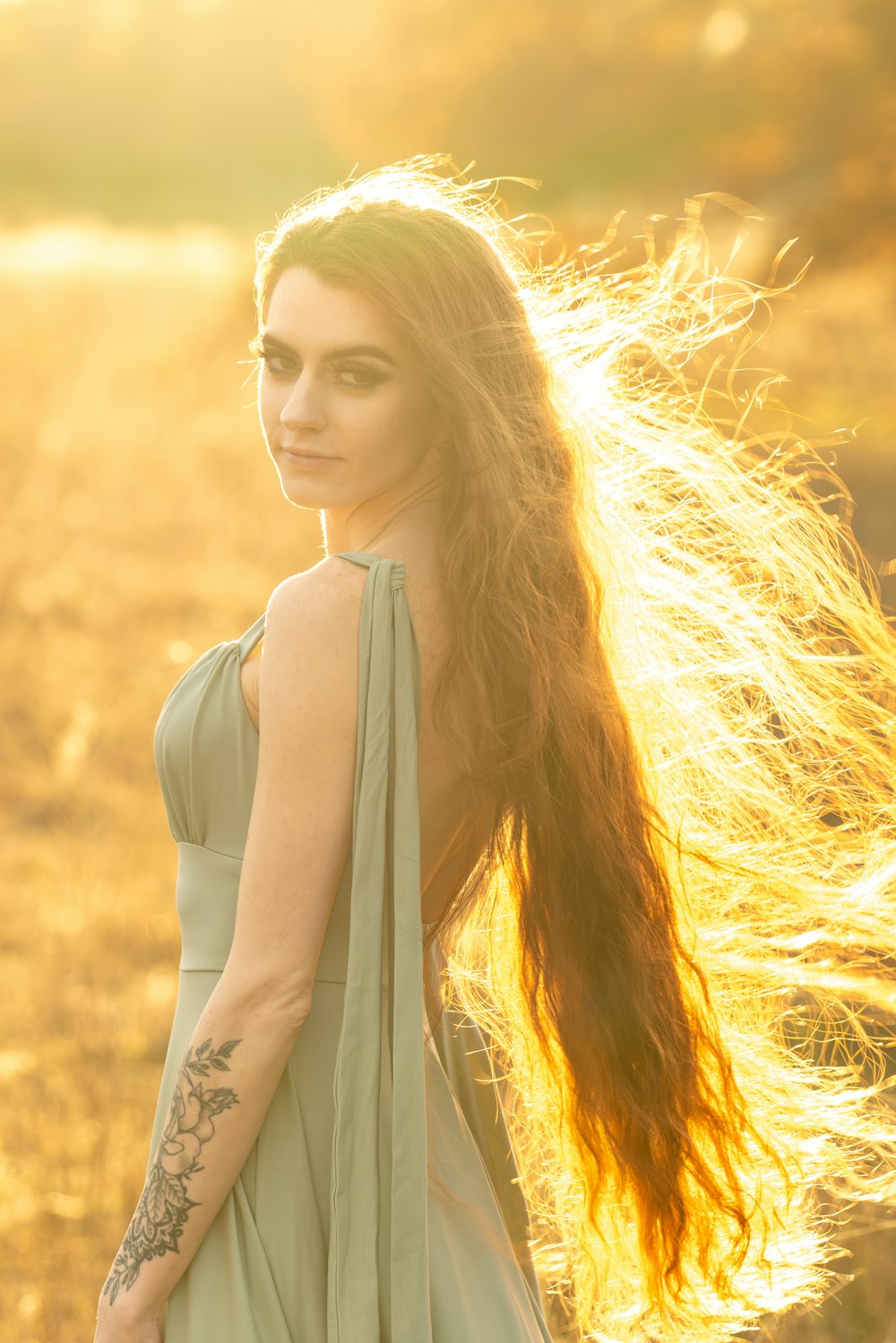 a woman with long hair standing in a field