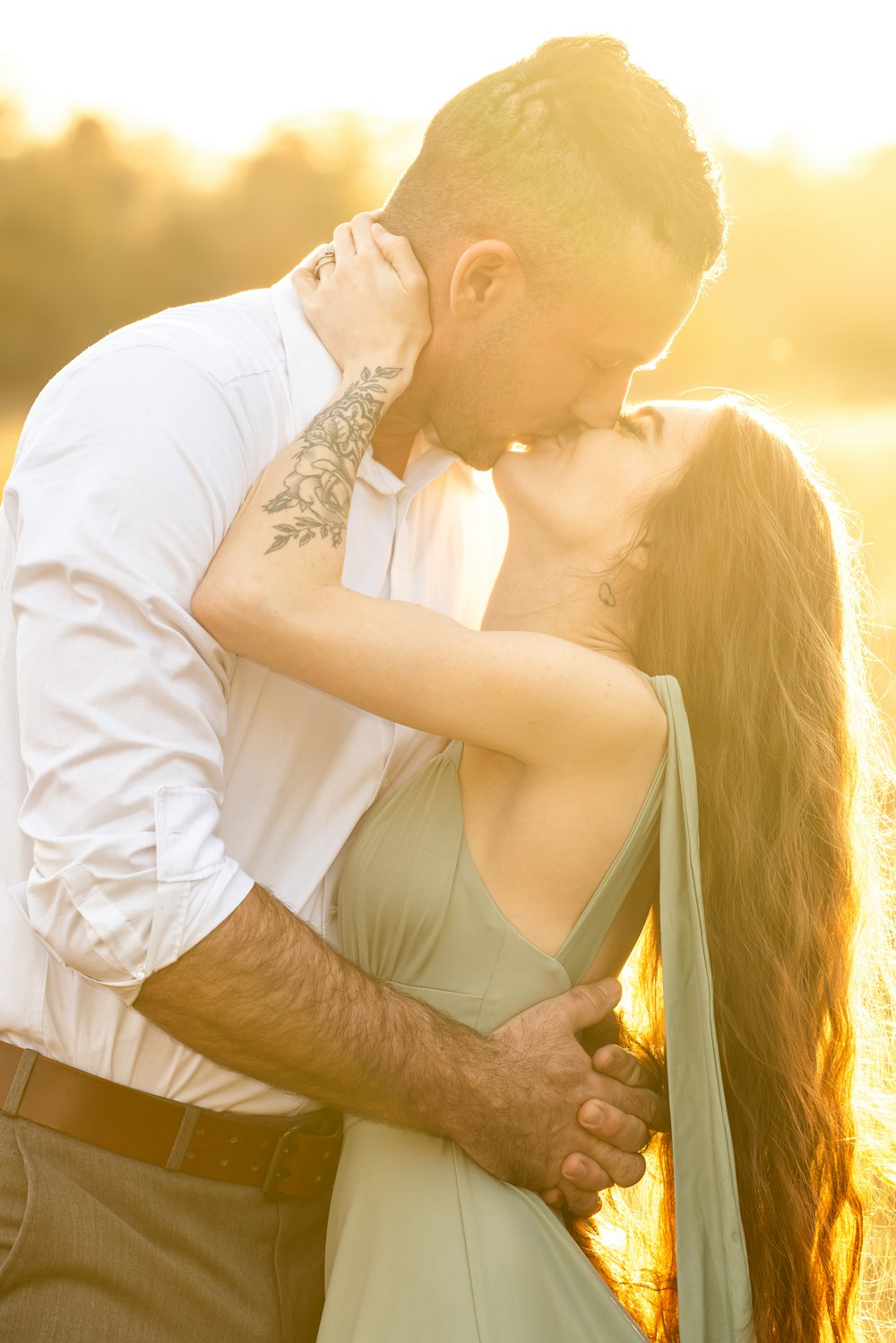 a man and a woman kissing in a field