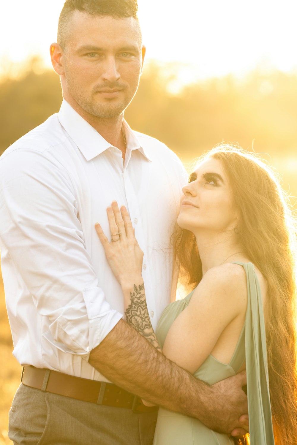 a man standing next to a woman in a field