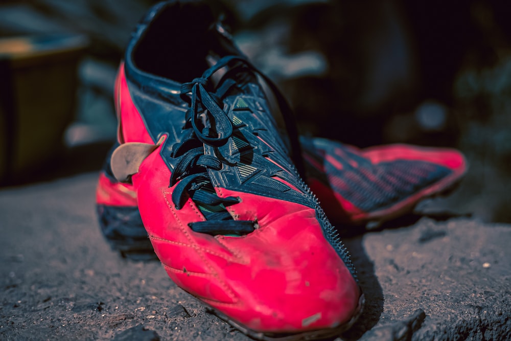 a pair of red and black shoes on a rock