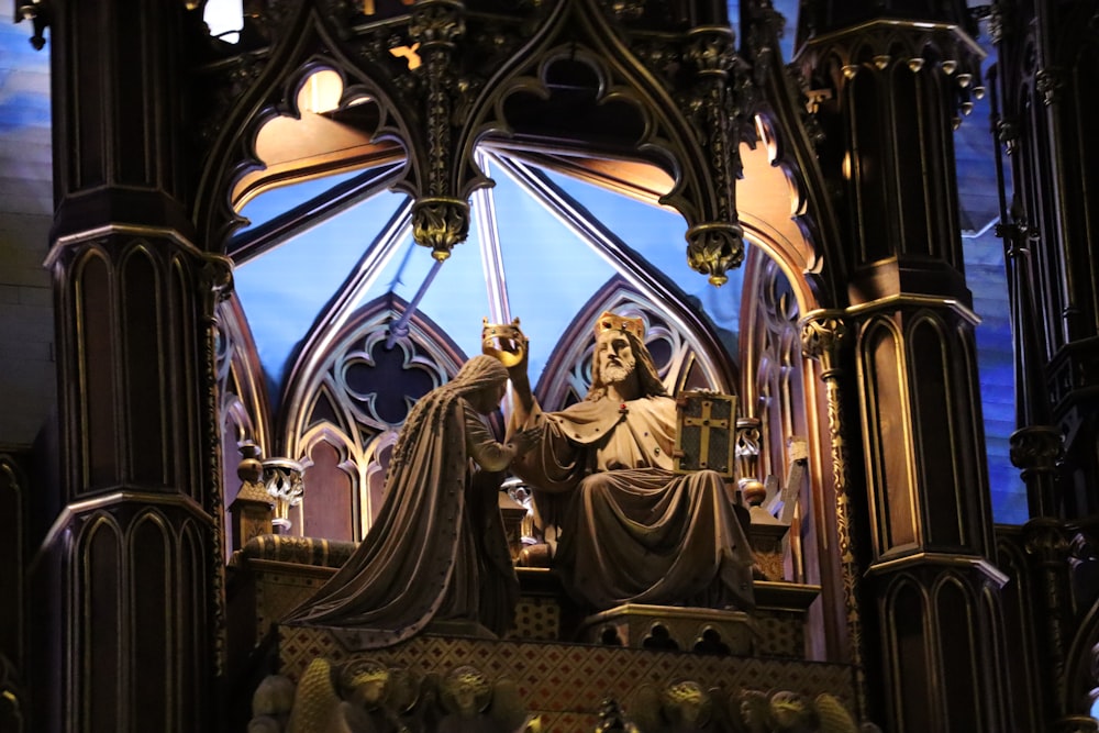 a statue of a man with a crown in front of a stained glass window