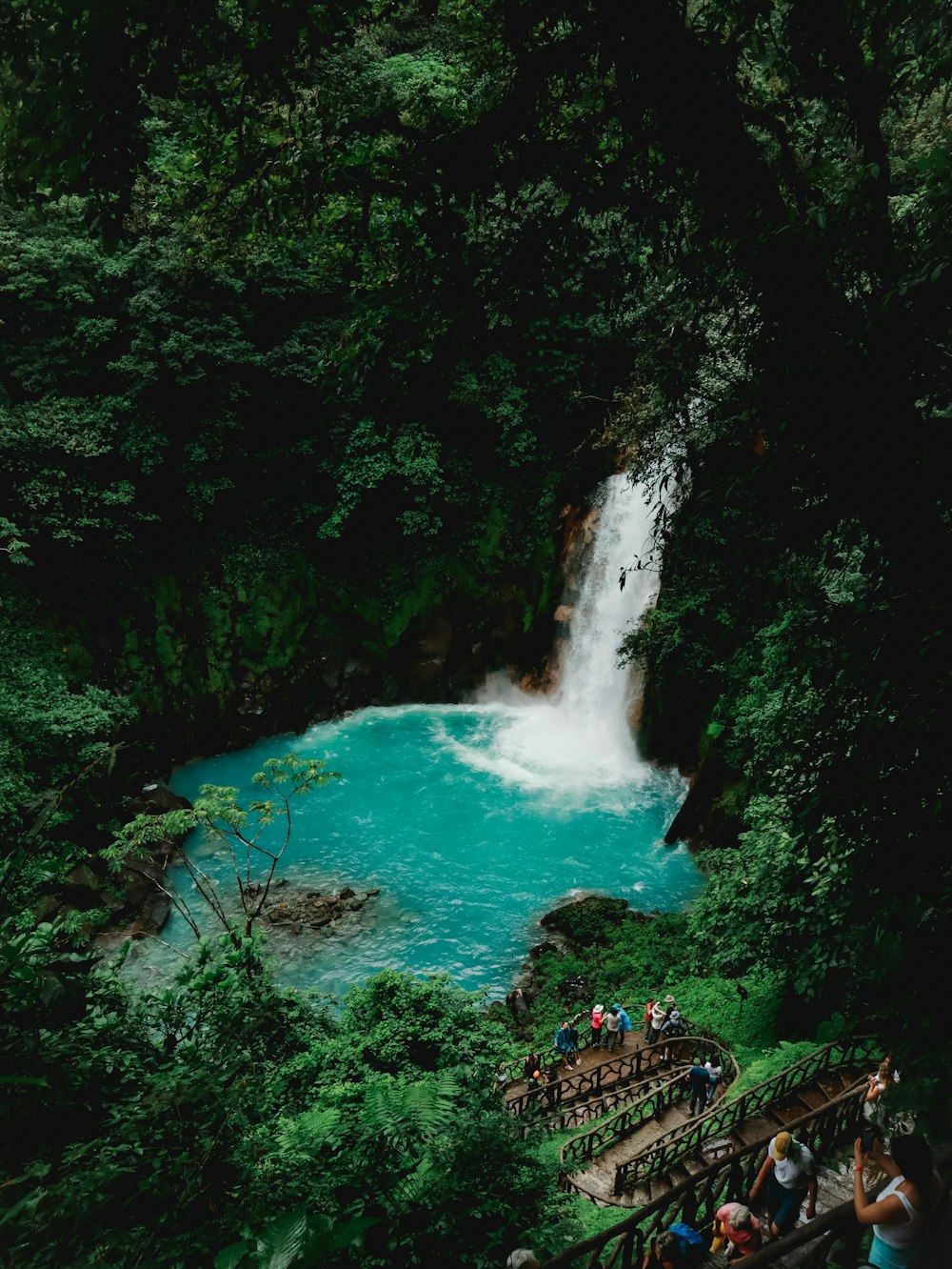 un groupe de personnes debout devant une cascade