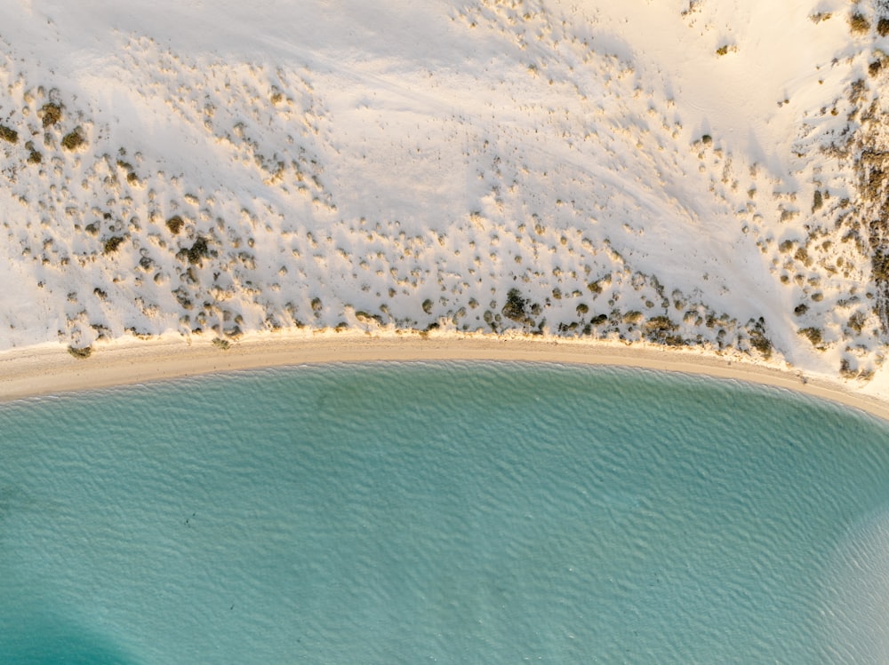 a body of water surrounded by snow covered mountains