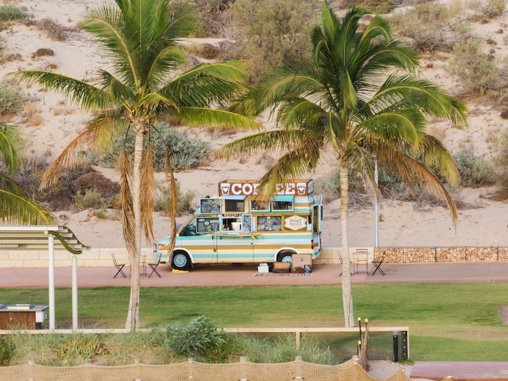 a food truck parked in front of palm trees