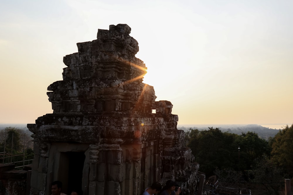 a group of people standing around a stone structure