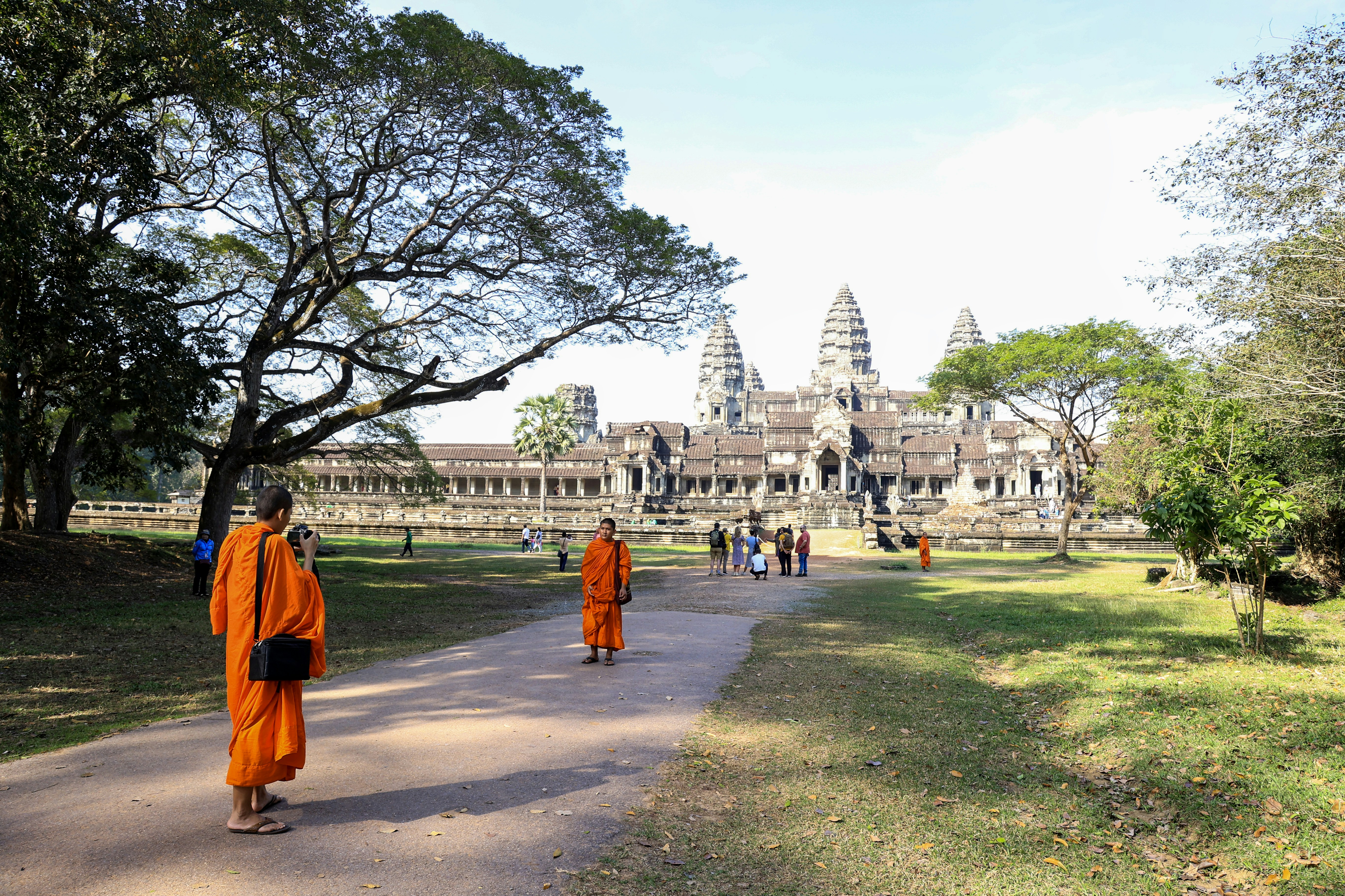 a group of monks walking in front of a large building