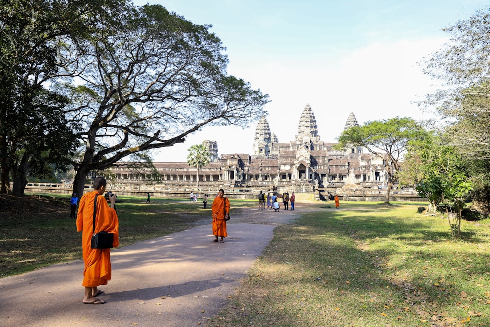 a group of monks walking in front of a large building