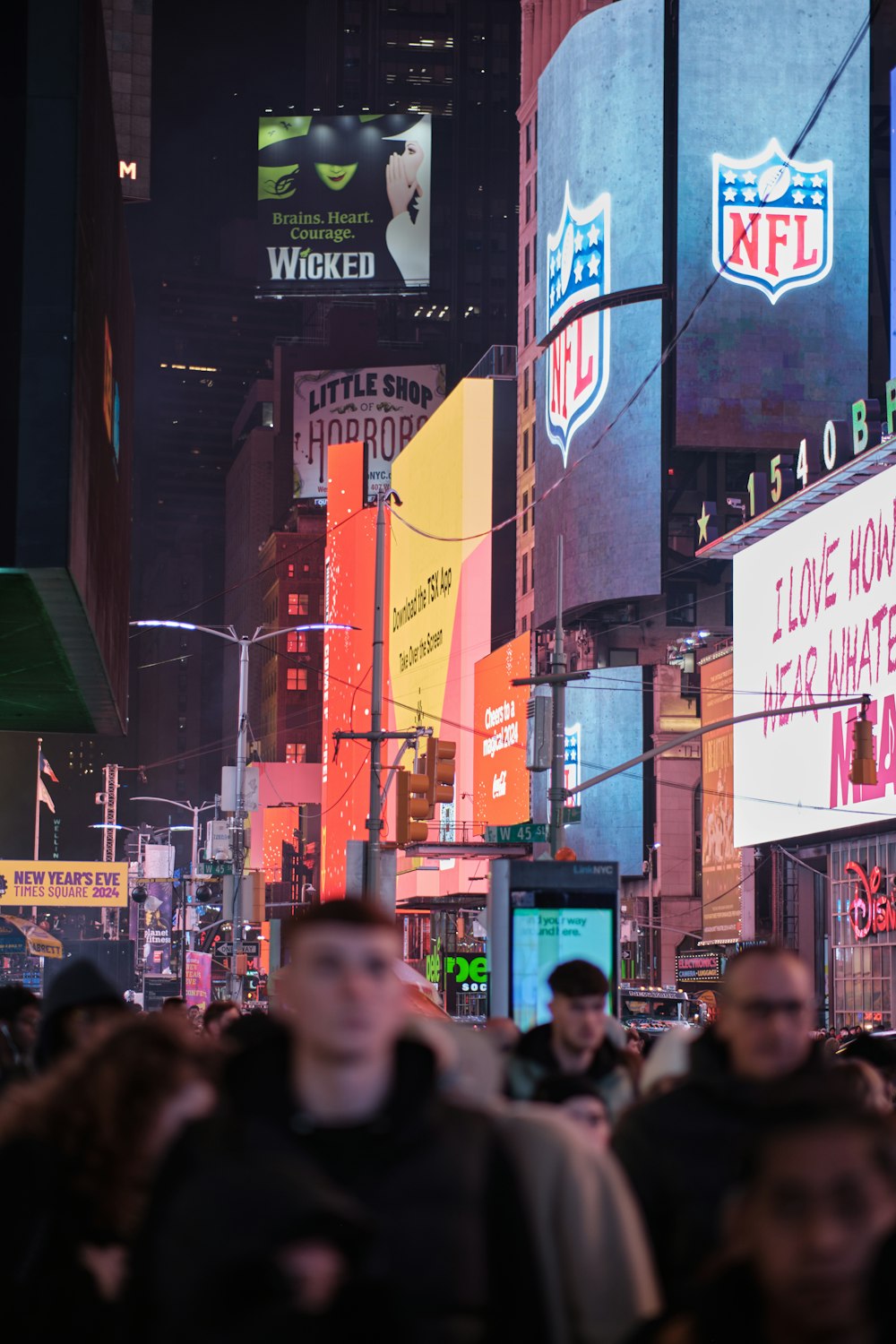 a crowd of people walking down a street next to tall buildings