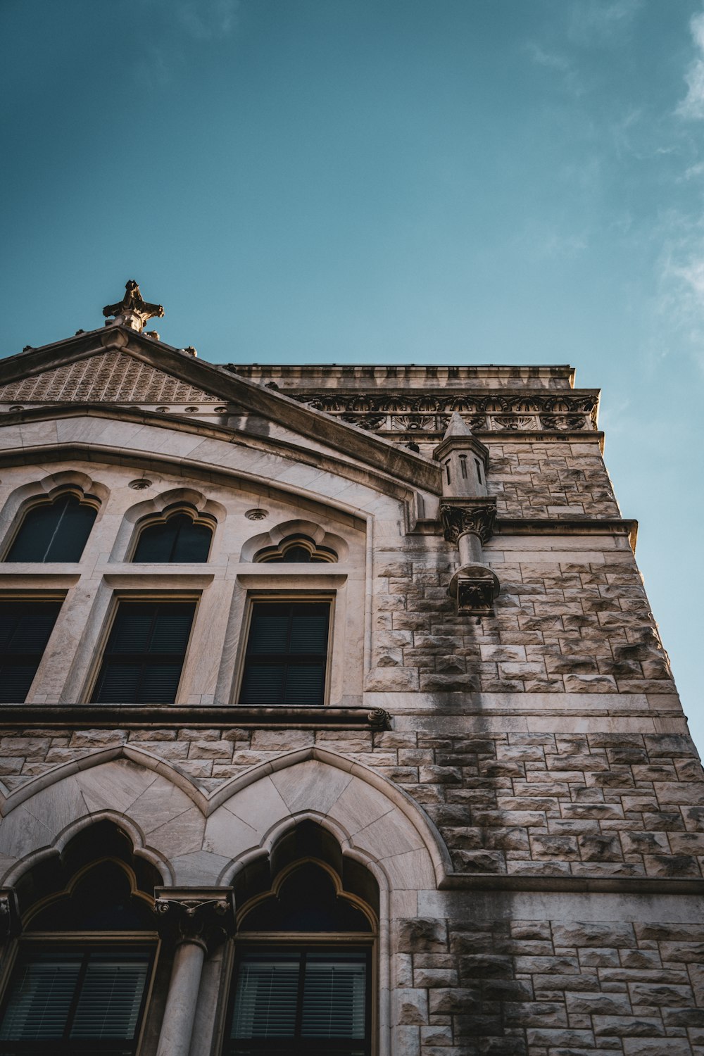 a tall brick building with a cross on top of it