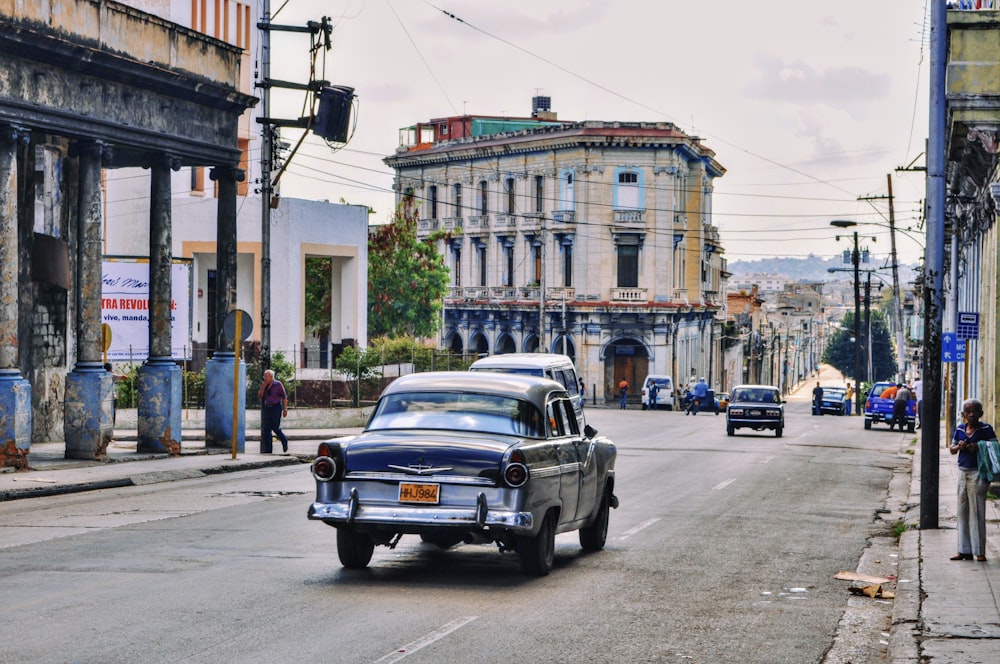 a car driving down a street next to tall buildings