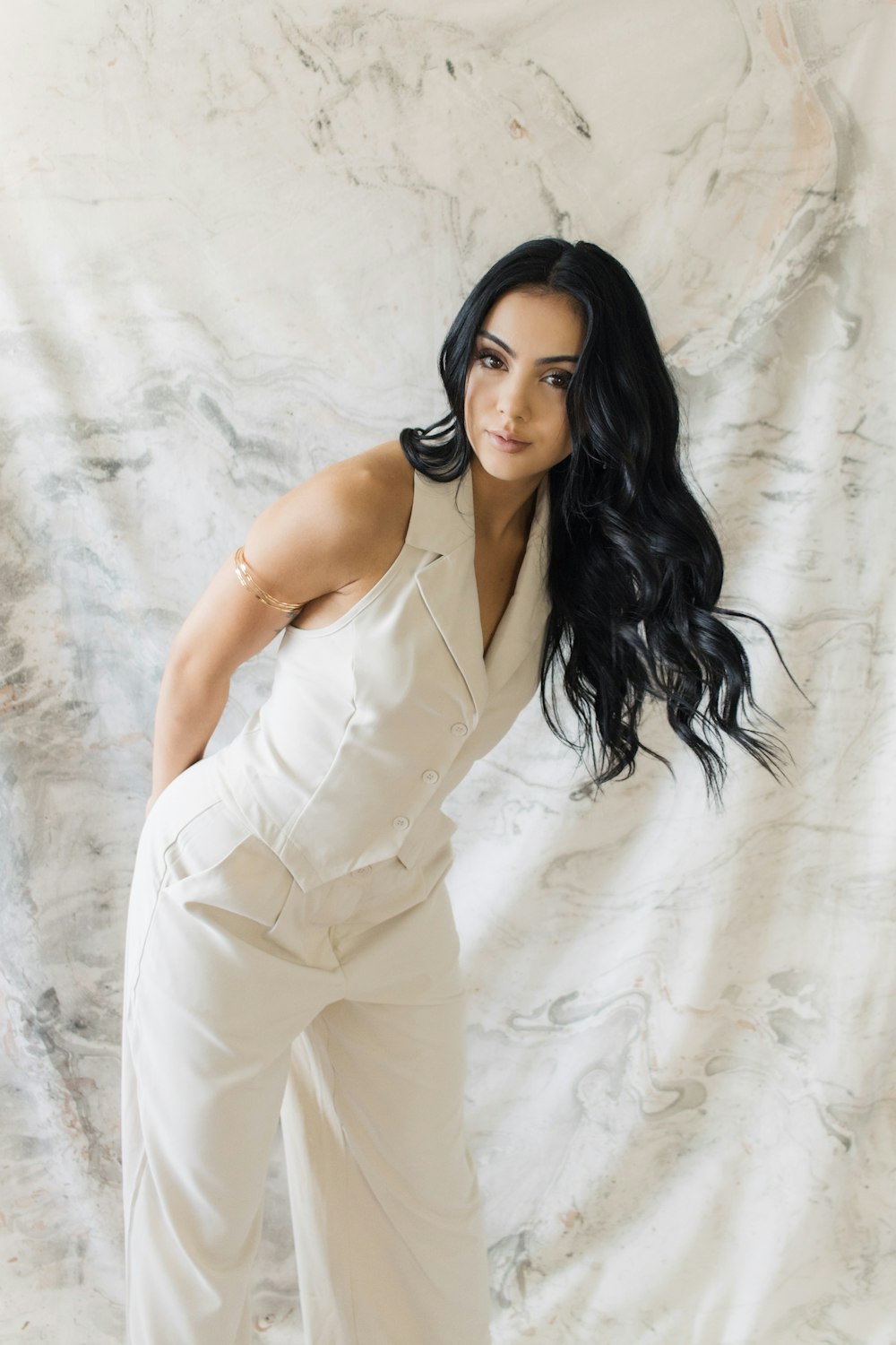 a woman in a white jumpsuit posing for a picture