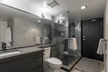 a bathroom with a shower, toilet and sink