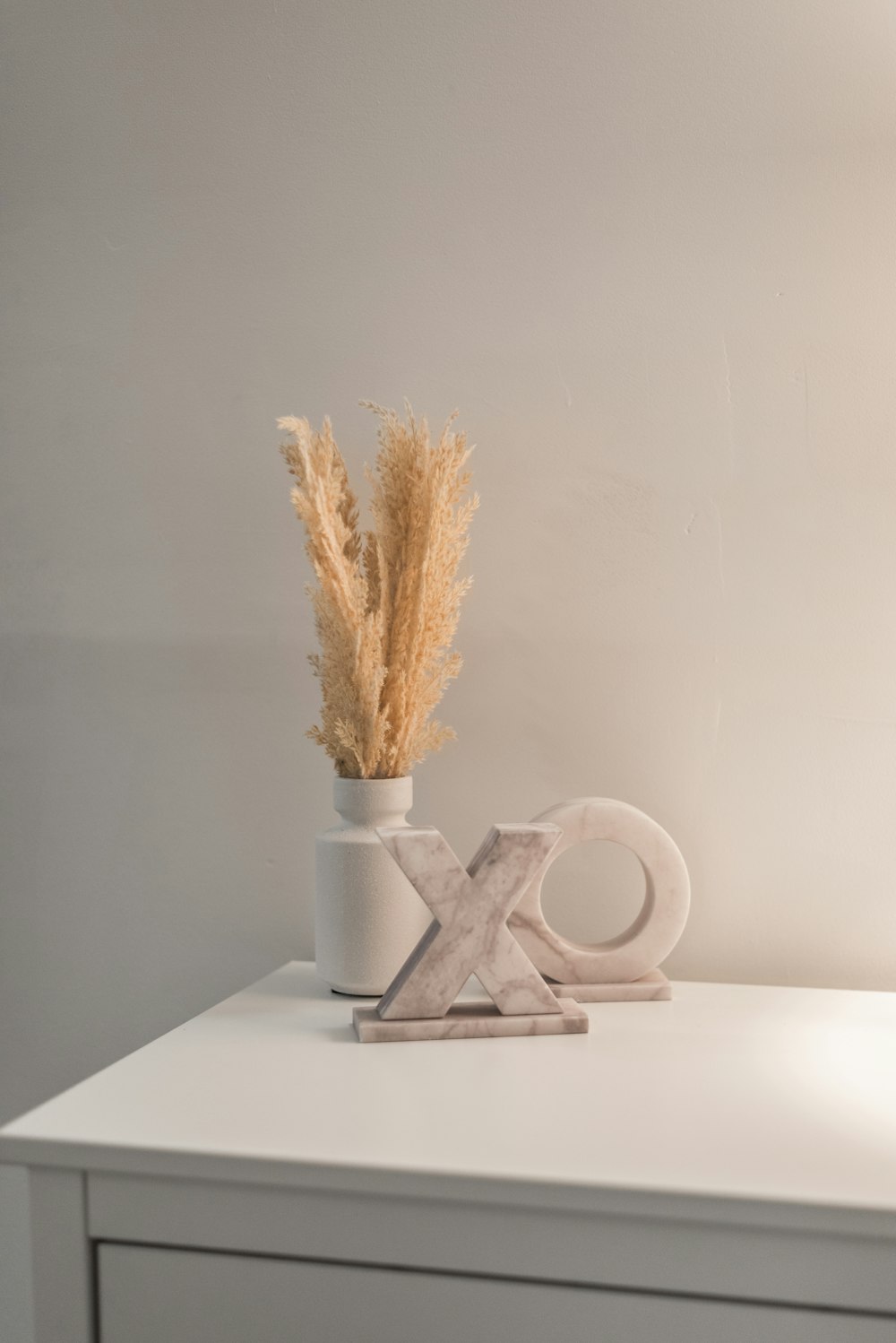 a white table with a vase and a pair of scissors on it