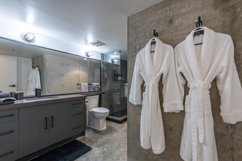a bathroom with two robes hanging on the wall