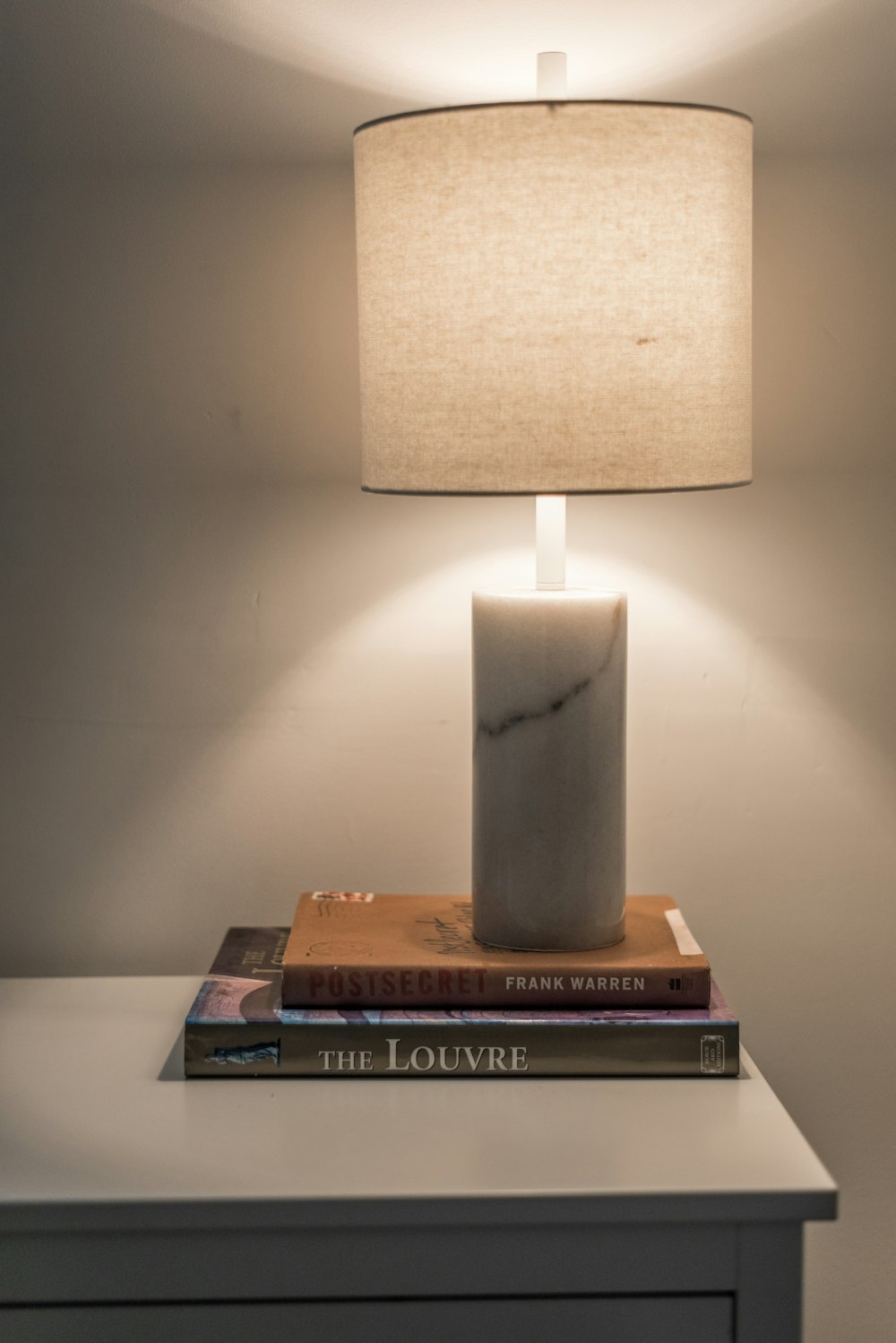 a lamp sitting on top of a table next to a book