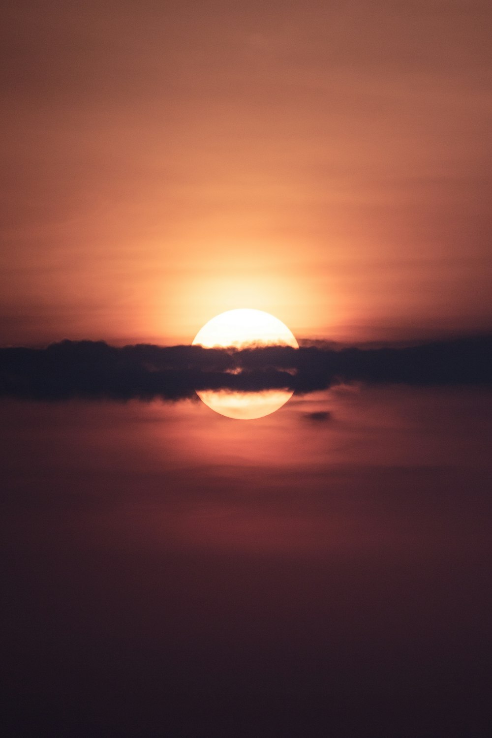 the sun is setting over the horizon of a body of water