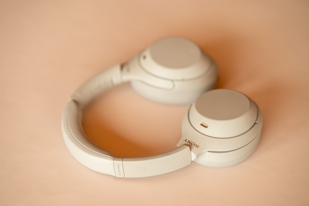 a pair of white headphones sitting on top of a table