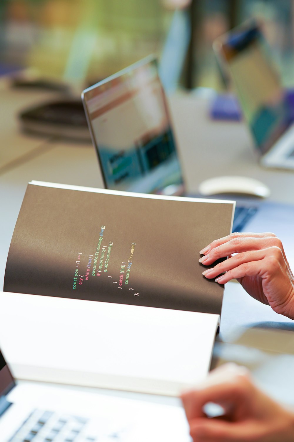 a person is holding a piece of paper in front of a laptop