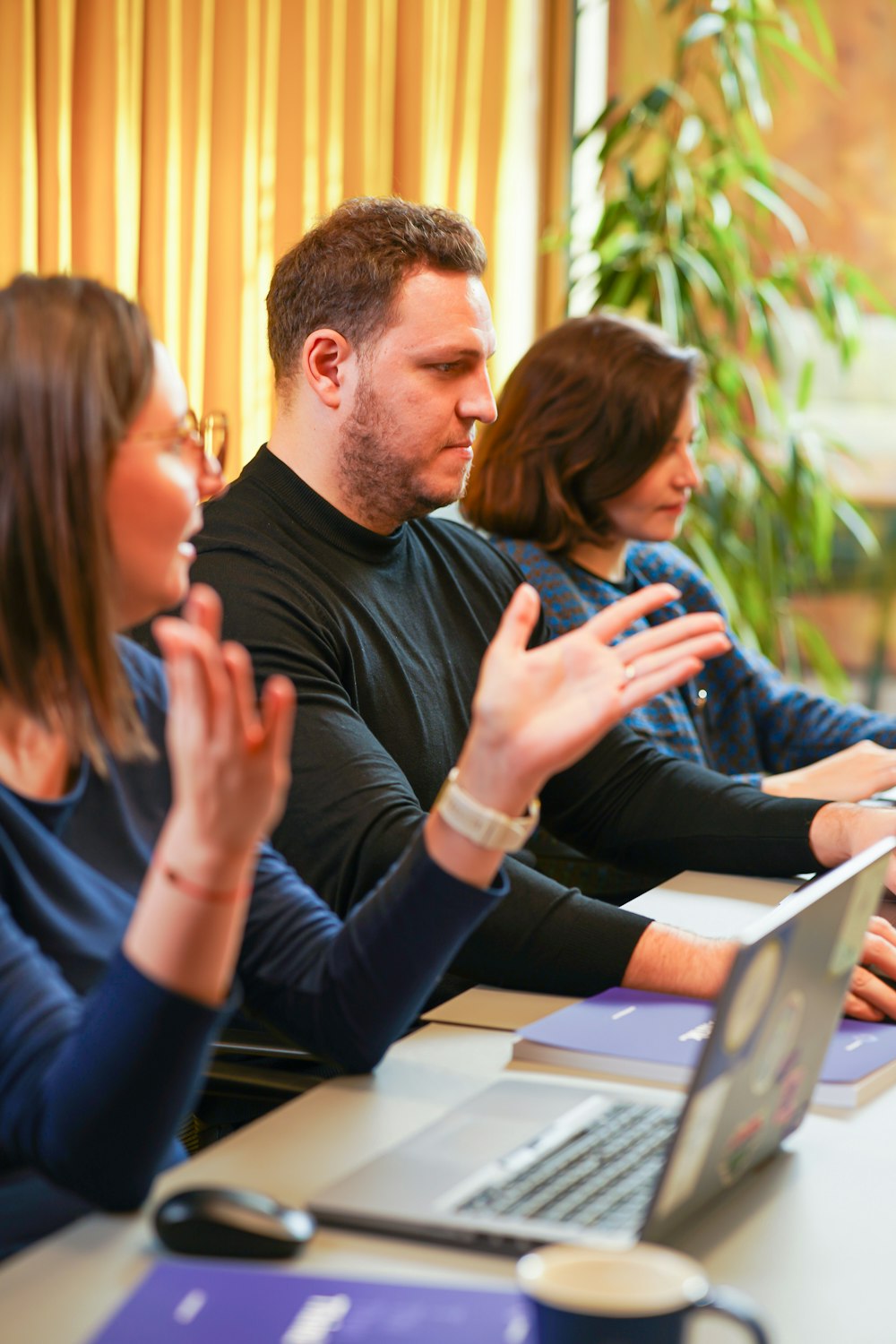 a group of people sitting at a table with a laptop