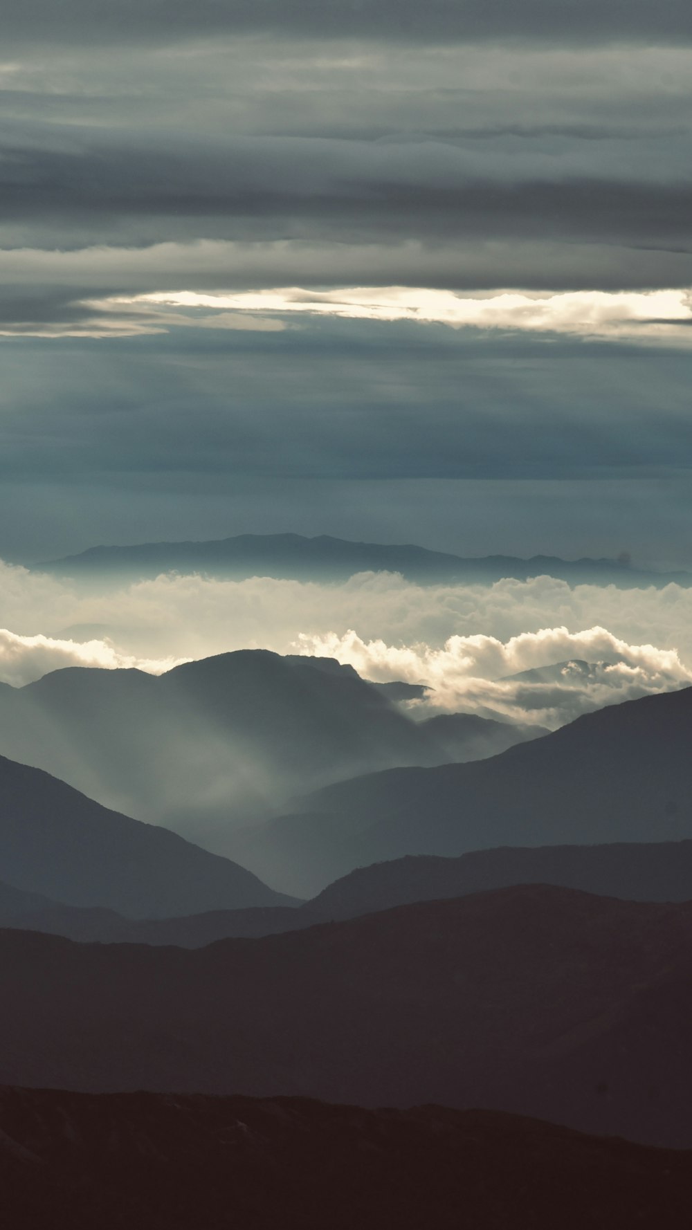 a view of a mountain range covered in clouds