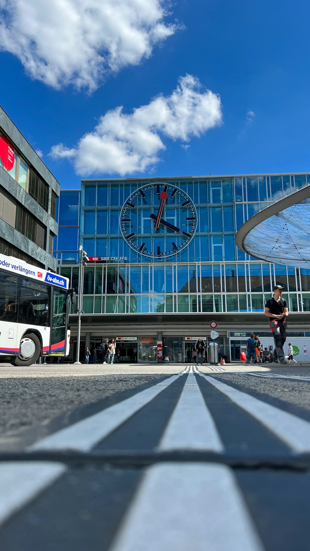a bus parked in front of a building with a clock on it