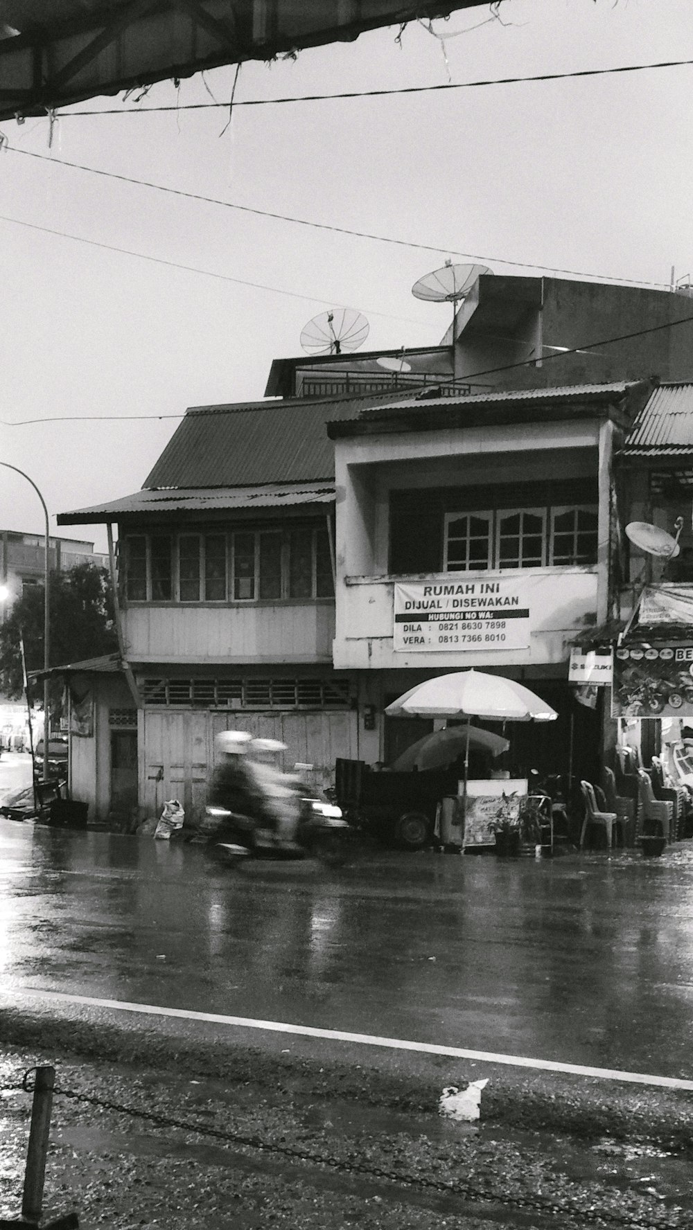 a black and white photo of a car driving down a street