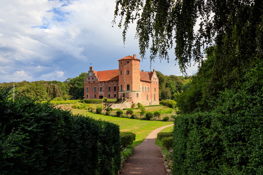 a large brick building sitting on top of a lush green field