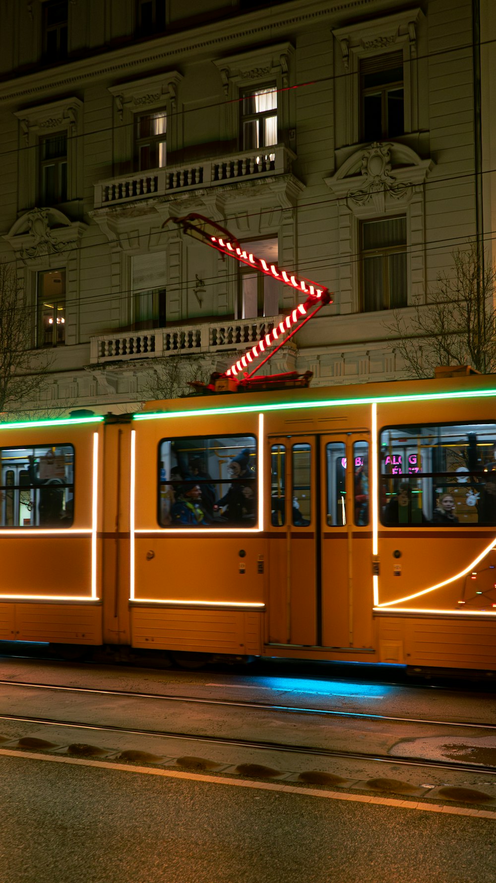 a trolley car with a neon sign on the side of it