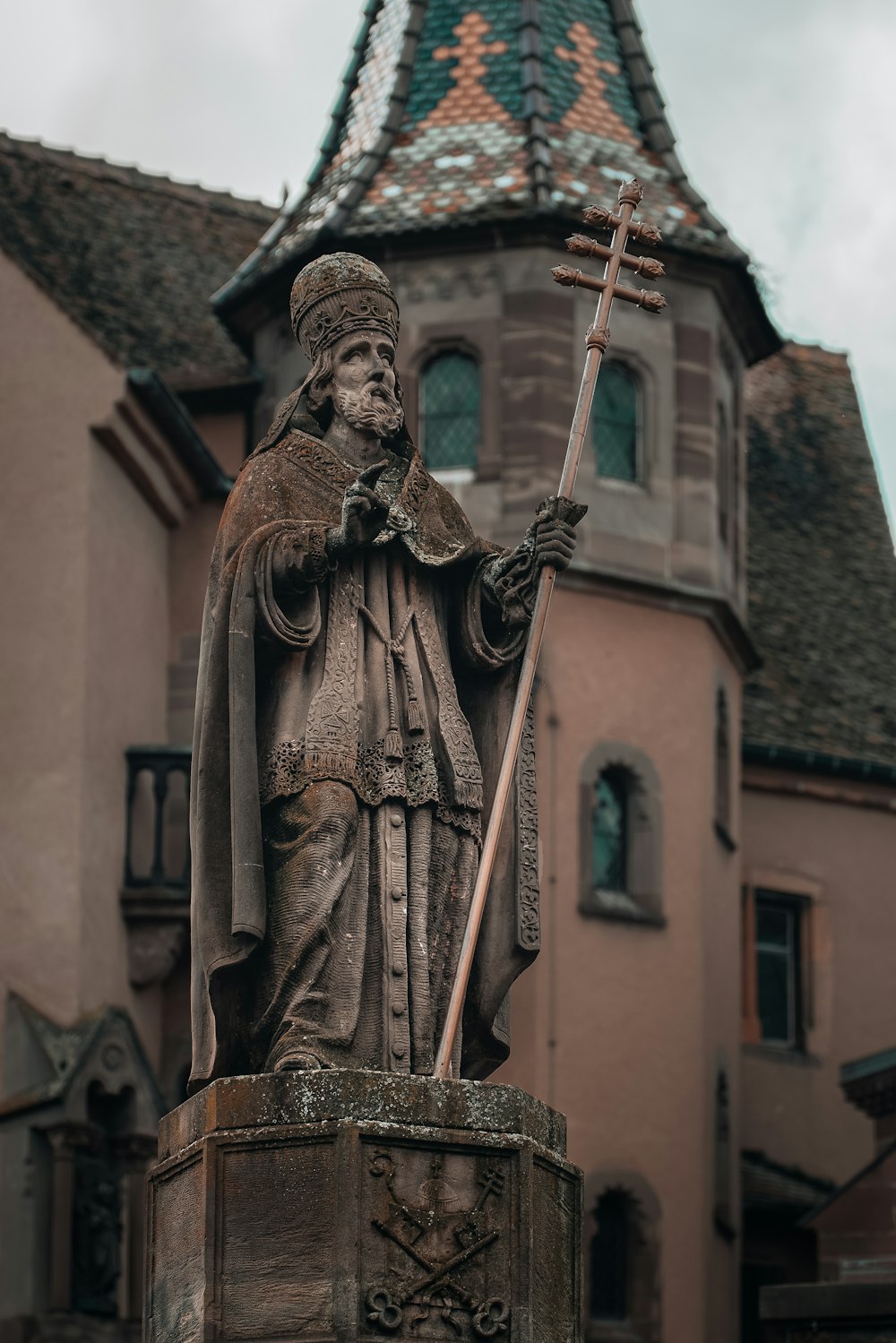 a statue of a man holding a cross in front of a building