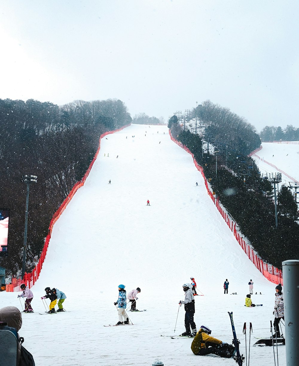 a group of people riding skis down a snow covered slope