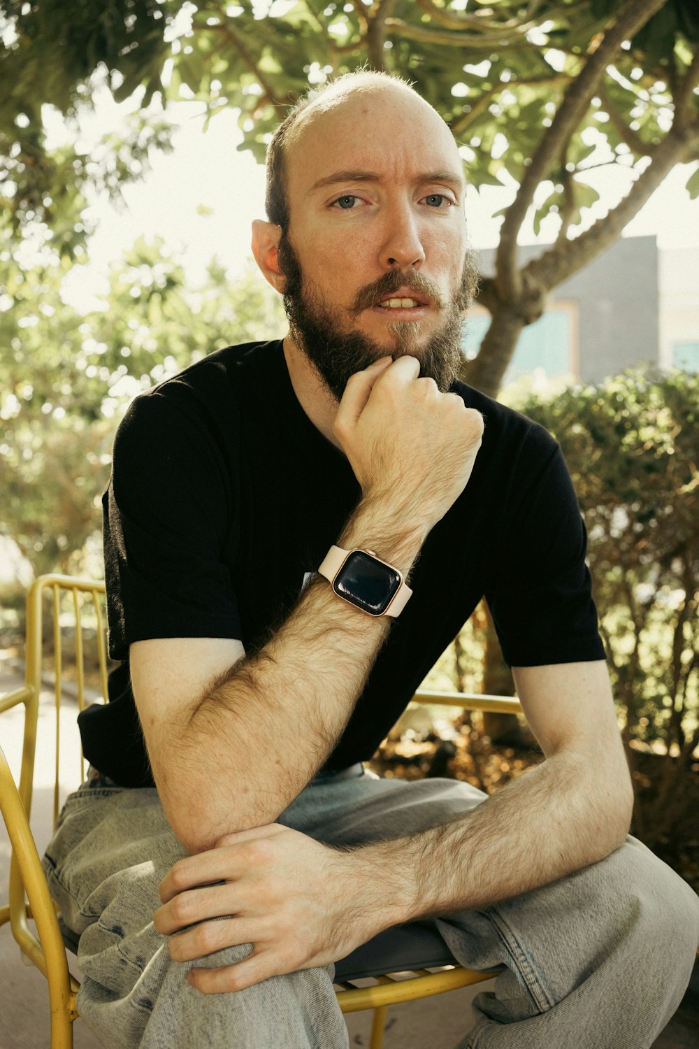 a man with a watch on his wrist sitting on a chair