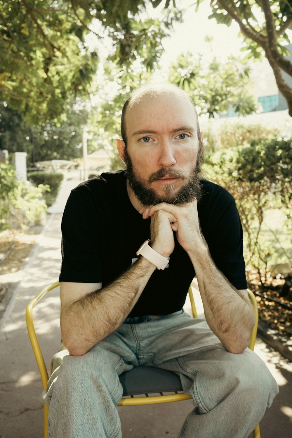 a man with a beard sitting on a yellow chair