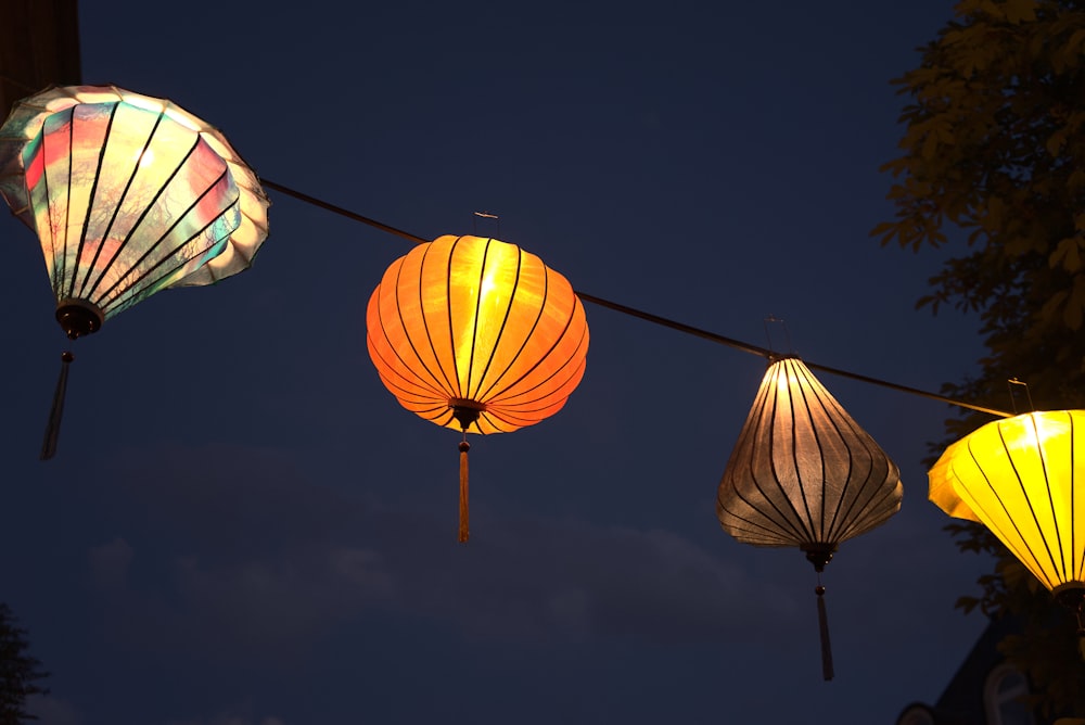 a string of colorful lanterns hanging from a tree