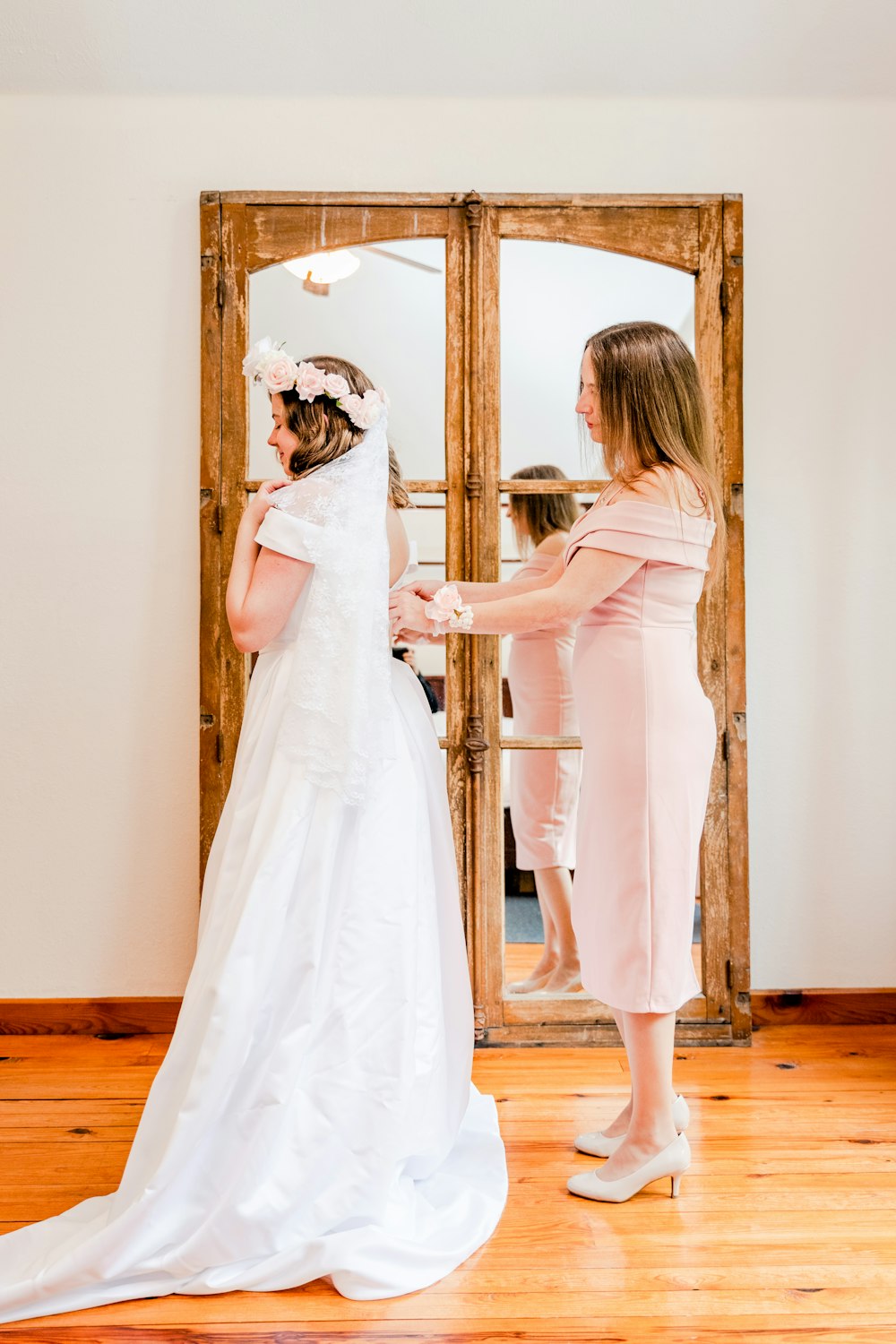 a woman in a wedding dress standing in front of a mirror