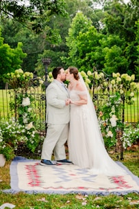 a bride and groom kissing in front of an iron gate