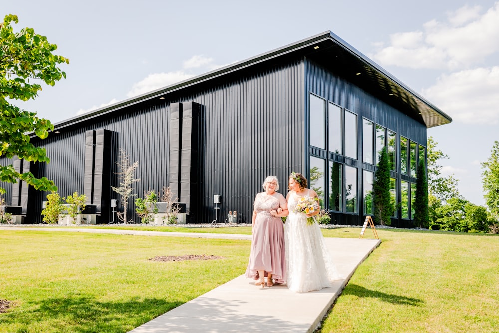 a couple of women standing next to each other in front of a building