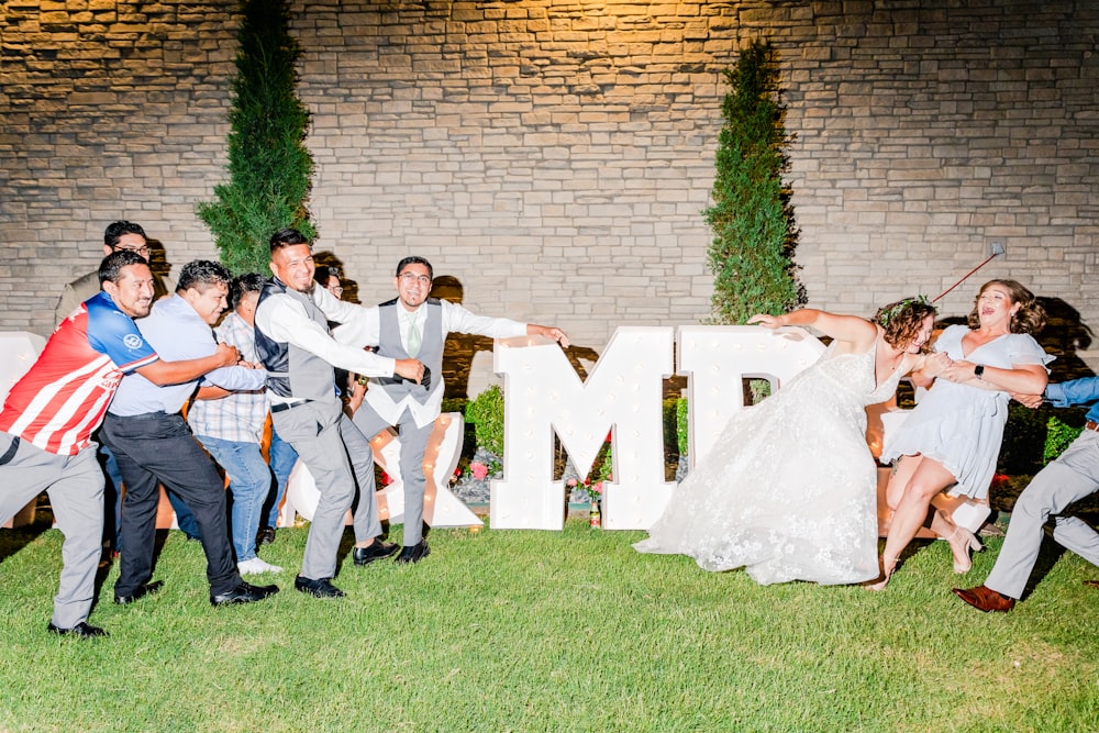 a bride and groom dancing in front of a sign