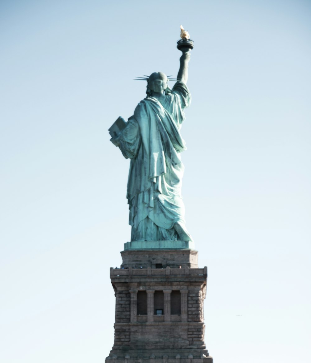 a statue of liberty with a bird in its hand