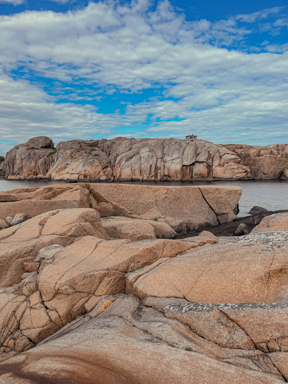 a rock formation with a body of water in the background