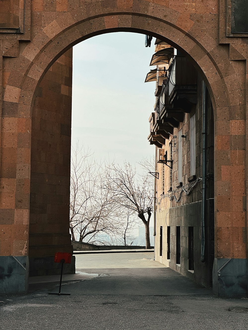 an arch in a brick building with a red fire hydrant