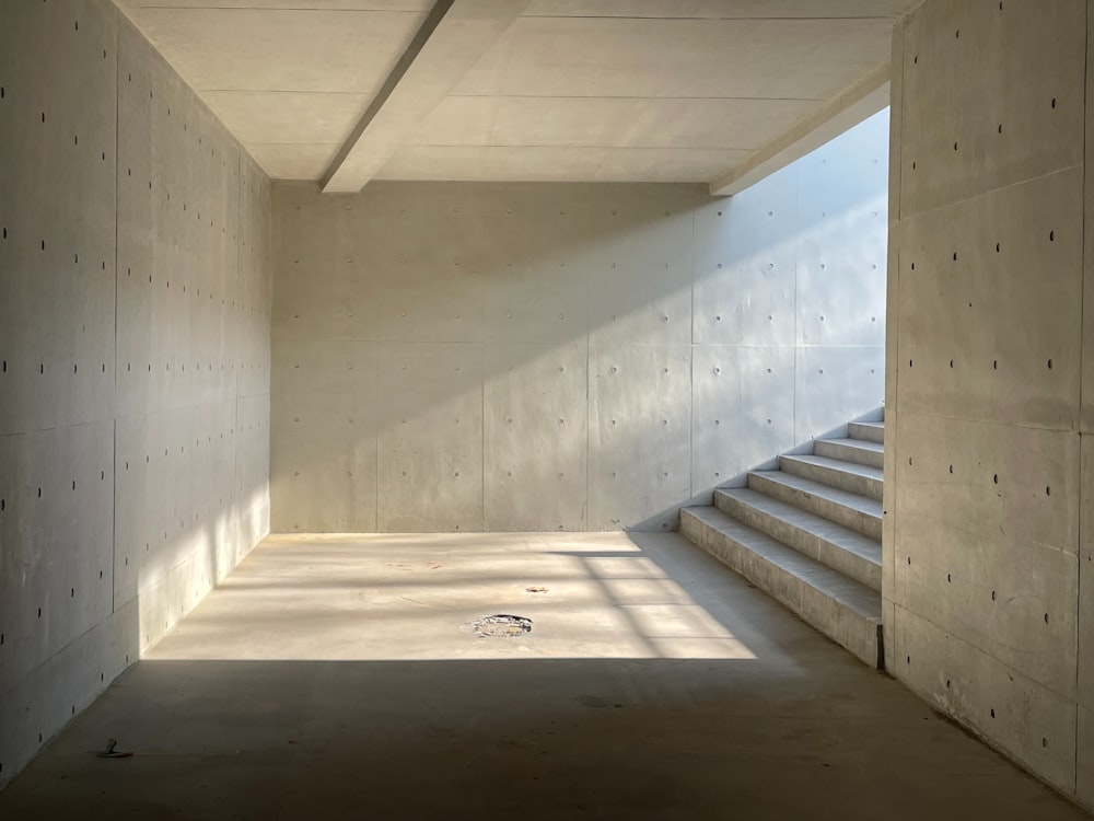 an empty room with concrete walls and stairs