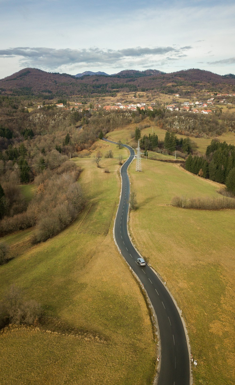 a winding road in the middle of a green field