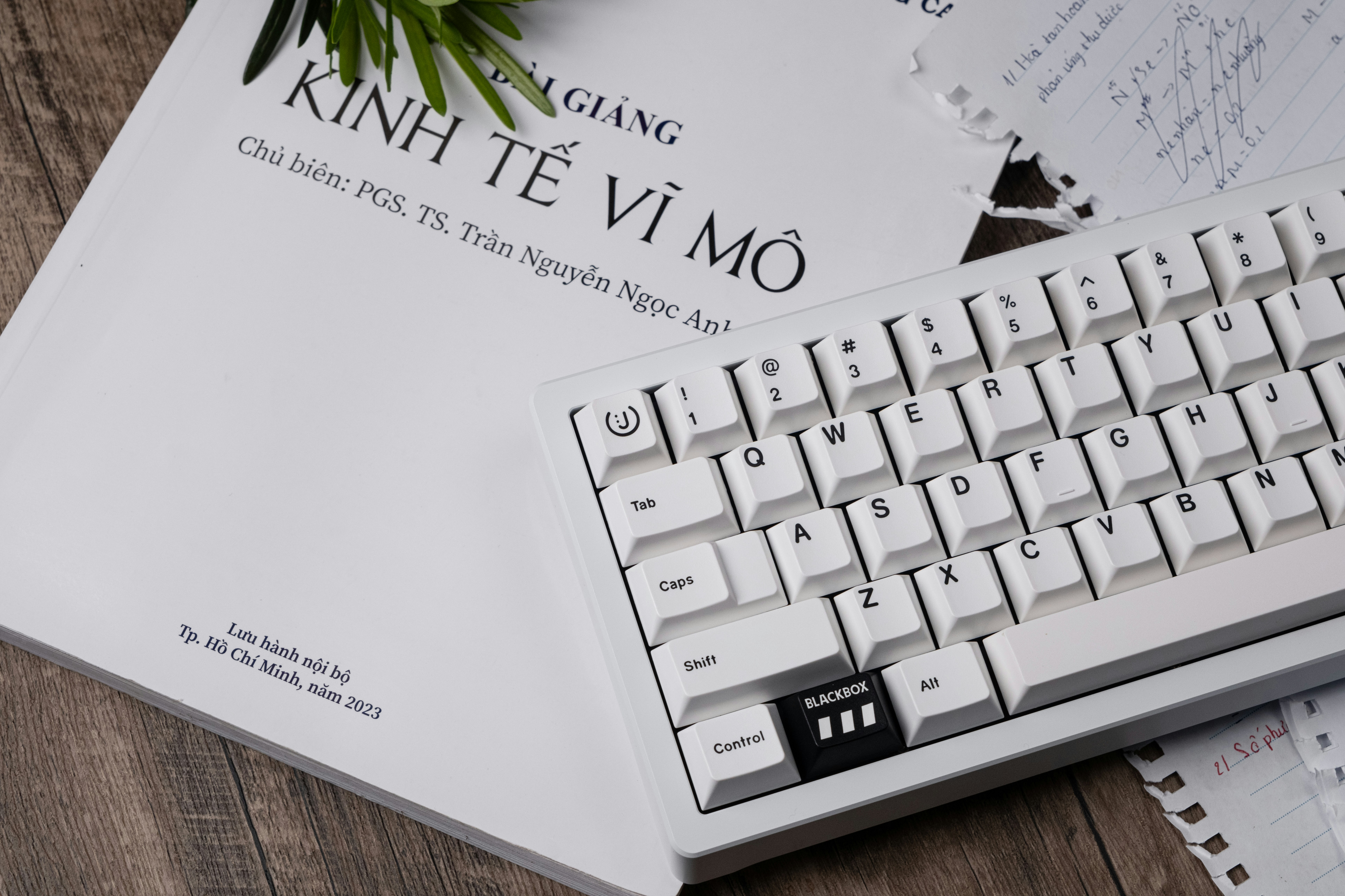 a white keyboard sitting on top of a wooden table