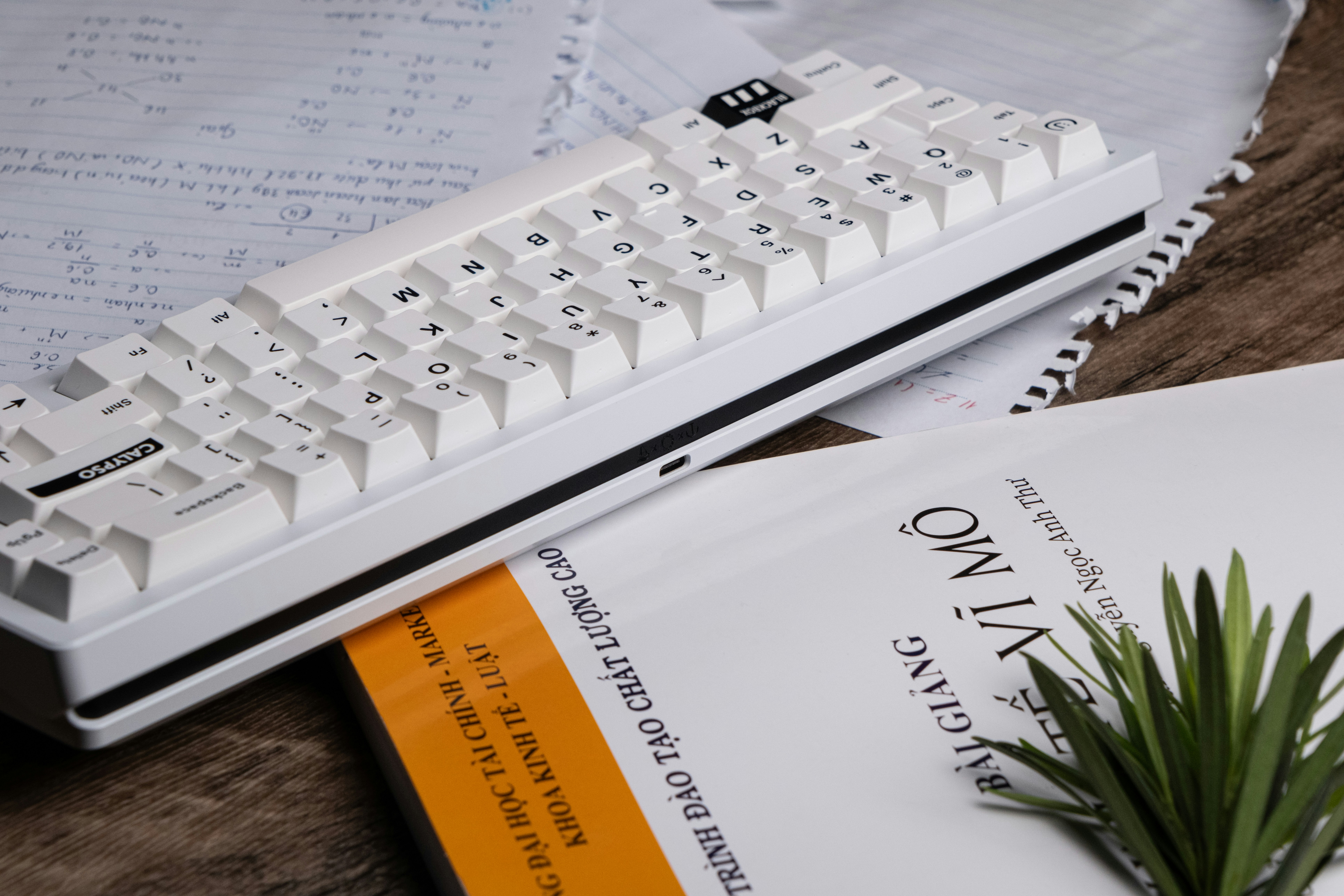 a white computer keyboard sitting on top of a book
