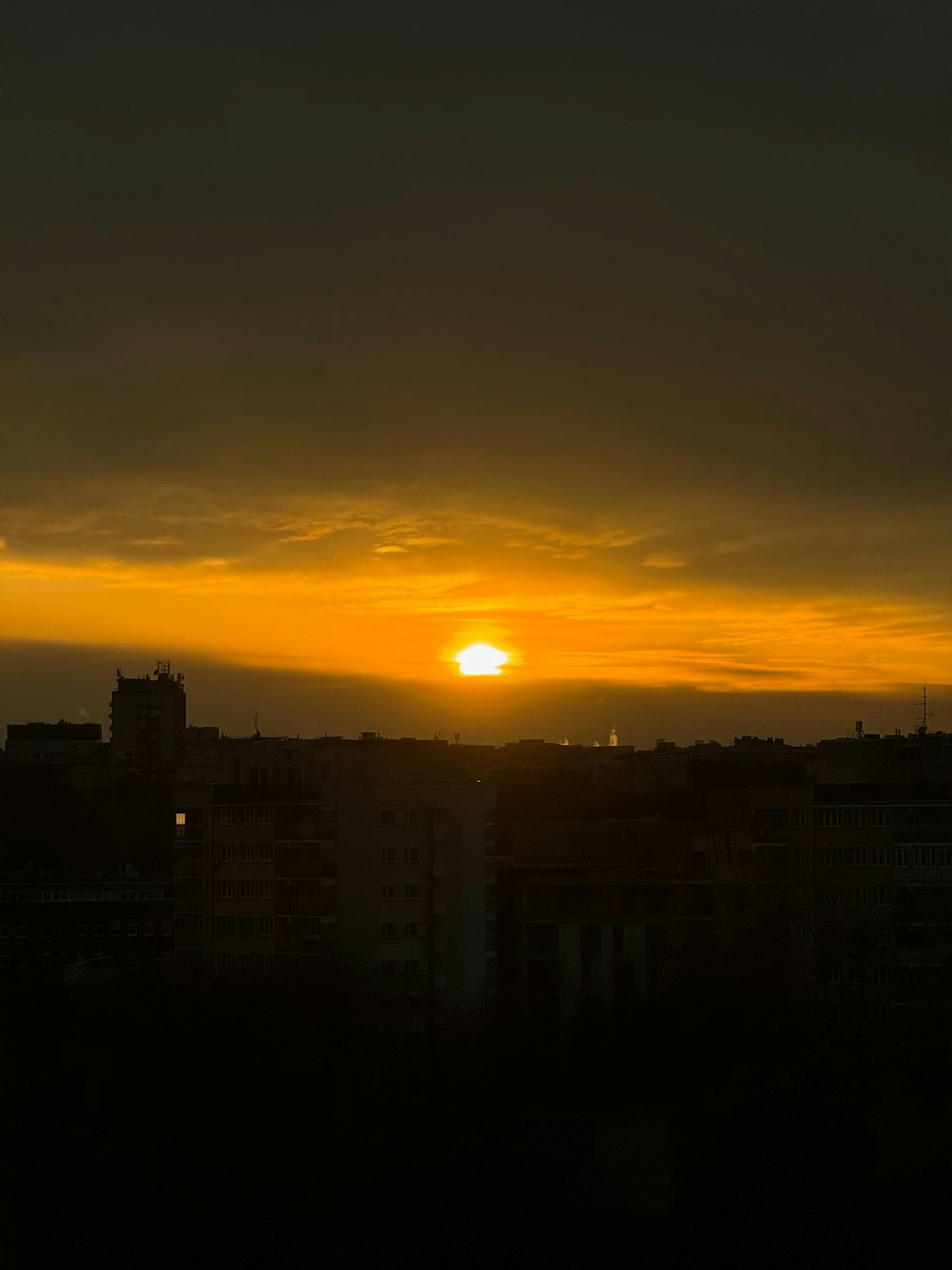Le soleil se couche sur une ville aux grands immeubles