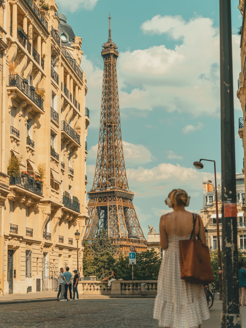 Una donna in abito bianco in piedi davanti alla Torre Eiffel